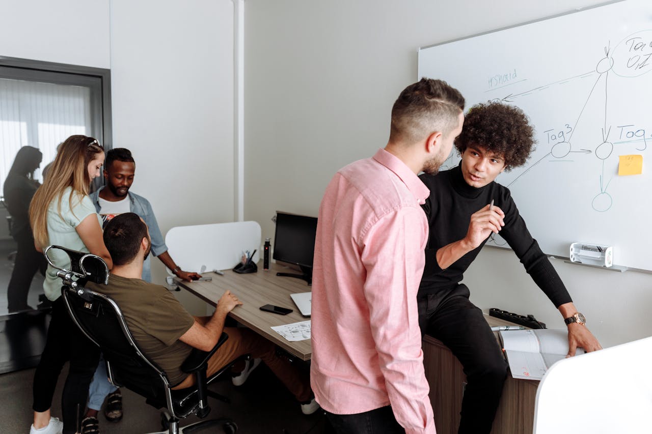 Diverse team engaged in productive office discussion, sharing ideas on a project.